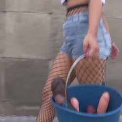 Ada, 19 years old, strolls around with a bucket full of dildos that carry the name of the performer who is going to deflower her ass